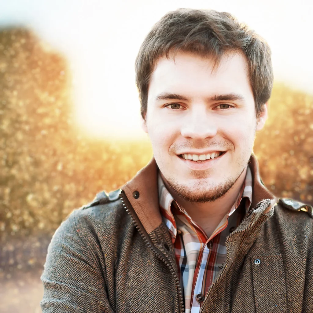 close-up-smiling-man-field-sunset